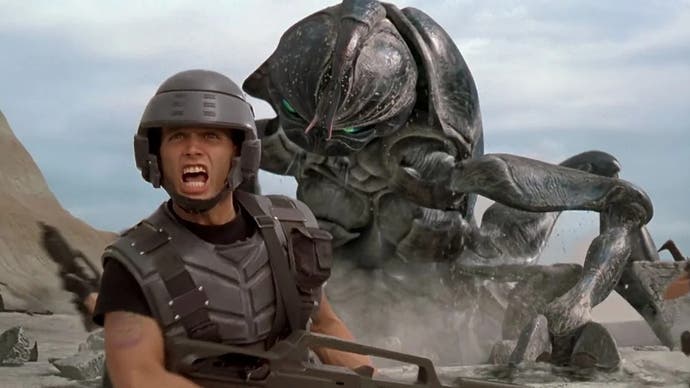 Starship Troopers film still showing a male character running from a giant bug-like enemy
